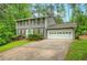 Charming two-story home boasts a manicured lawn, mature trees, and an attached two-car garage at 4536 Mountain Creek Ne Dr, Roswell, GA 30075