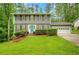 Charming two-story home featuring a well-manicured lawn, a light blue front door and an attached two-car garage at 4536 Mountain Creek Ne Dr, Roswell, GA 30075