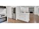 Modern kitchen with stainless steel appliances, white cabinets, an island with white countertops, and hardwood floors at 4536 Mountain Creek Ne Dr, Roswell, GA 30075