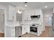 Modern white kitchen featuring stainless steel appliances, white cabinets, quartz countertops, and gold hardware at 4536 Mountain Creek Ne Dr, Roswell, GA 30075