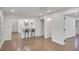 Open-concept living area with hardwood floors connecting to a modern white kitchen with a breakfast bar and bar stools at 4536 Mountain Creek Ne Dr, Roswell, GA 30075