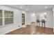 Bright open living area with hardwood floors, a kitchen with a breakfast bar, and large windows with backyard views at 4536 Mountain Creek Ne Dr, Roswell, GA 30075