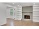Comfortable living room with hardwood floors, white built-in shelves, and a cozy gray brick fireplace at 4536 Mountain Creek Ne Dr, Roswell, GA 30075