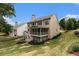 A home's spacious backyard features a screened porch, a well-manicured lawn, and mature trees at 139 Ardsley Run, Canton, GA 30115