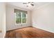 Bright bedroom featuring hardwood floors and a window overlooking a green landscape at 139 Ardsley Run, Canton, GA 30115