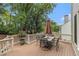 Outdoor deck with a dining table, chairs, and lush landscaping for alfresco dining and relaxation at 139 Ardsley Run, Canton, GA 30115