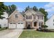 Charming brick two-story home featuring a well-manicured lawn and a two-car garage at 139 Ardsley Run, Canton, GA 30115