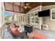Inviting screened-in patio with comfortable seating, a fireplace, and a mounted TV for outdoor enjoyment at 139 Ardsley Run, Canton, GA 30115