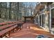 Large wooden deck with railings and bench, with a screened porch and view of the wooded area at 337 Andrew Bailey Rd, Sharpsburg, GA 30277