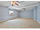 Spacious carpeted bedroom with a window air conditioning unit and two ceiling fans at 337 Andrew Bailey Rd, Sharpsburg, GA 30277