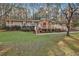 Ranch-style house with a front deck, stone chimney, green lawn and mature trees at 337 Andrew Bailey Rd, Sharpsburg, GA 30277
