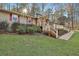 Ranch-style house with a front deck, stone chimney, green lawn and mature trees at 337 Andrew Bailey Rd, Sharpsburg, GA 30277