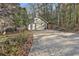 Two car detached garage with driveway leading to the main house surrounded by mature trees at 337 Andrew Bailey Rd, Sharpsburg, GA 30277