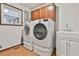 Bright laundry room features a modern washer and dryer set, with storage cabinets and a window for natural light at 337 Andrew Bailey Rd, Sharpsburg, GA 30277