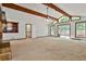 Large living room with exposed beams, a stone fireplace, and sliding glass doors at 337 Andrew Bailey Rd, Sharpsburg, GA 30277