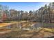 Scenic view of a home beyond a pond surrounded by lush trees and grass at 337 Andrew Bailey Rd, Sharpsburg, GA 30277