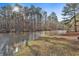 Scenic view of a pond surrounded by mature trees and grassy shores, reflecting sunlight at 337 Andrew Bailey Rd, Sharpsburg, GA 30277