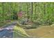 Picturesque view of the pond, leading to a charming home nestled amongst the trees at 337 Andrew Bailey Rd, Sharpsburg, GA 30277
