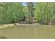 Beautiful view of home behind a pond with mature trees and lush greenery surrounding the property at 337 Andrew Bailey Rd, Sharpsburg, GA 30277