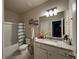 Well-lit bathroom with granite countertop, framed mirror, and a shower/tub combo at 3566 Andover Way, Buford, GA 30519