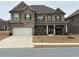 Charming two-story home with brick and stone accents, covered porch, and well-maintained landscaping at 3566 Andover Way, Buford, GA 30519