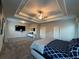 Large carpeted main bedroom featuring a trey ceiling, ceiling fan, and a television at 3566 Andover Way, Buford, GA 30519
