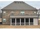 Spacious backyard view of a home featuring a screened-in porch and brick exterior at 3566 Andover Way, Buford, GA 30519