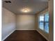 Bright room with hardwood floors, a large window with blinds, and neutral paint at 3566 Andover Way, Buford, GA 30519