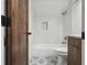 Modern bathroom featuring a shower-tub combo with sleek white tiling and stylish fixtures at 3567 Beachhill Dr, Atlanta, GA 30340