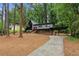 Striking two-story house featuring a carport and angular architectural details nestled in a lush, wooded landscape at 3567 Beachhill Dr, Atlanta, GA 30340