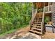 Exterior view of back deck with wooden stairs and lush greenery around at 588 Peachtree Se Dr, White, GA 30184