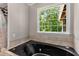 Main bath with a garden tub and a large window with treed outdoor views at 588 Peachtree Se Dr, White, GA 30184