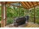 An inviting covered deck with wood flooring and a view of the surrounding trees offers a relaxing outdoor space at 588 Peachtree Se Dr, White, GA 30184