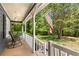 Inviting front porch featuring a chair, American flag, and serene views of the surrounding greenery at 588 Peachtree Se Dr, White, GA 30184