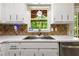 Kitchen sink in a well-lit kitchen with a view of the outdoor greenery at 588 Peachtree Se Dr, White, GA 30184