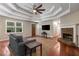 Bright living room showcasing hardwood floors, a stone fireplace, and an elegant tray ceiling at 588 Peachtree Se Dr, White, GA 30184