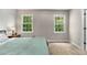 Bedroom features carpet and two windows with treed outdoor views at 588 Peachtree Se Dr, White, GA 30184