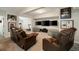 Finished basement with plush seating, multiple TVs, and workout equipment beyond the room at 690 Cobblestone Creek Ln, Mableton, GA 30126