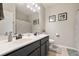 Neutral toned bathroom featuring a double sink vanity, framed art and decorative shower curtain at 690 Cobblestone Creek Ln, Mableton, GA 30126