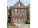 Two-story townhome featuring brick and stone facade, well-maintained landscaping, and a two-car garage at 690 Cobblestone Creek Ln, Mableton, GA 30126