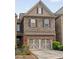 Charming two-story townhouse with a stone and brick facade, a two-car garage, and manicured landscaping at 690 Cobblestone Creek Ln, Mableton, GA 30126