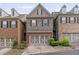 The townhome has mixed stone and brick, a two-car garage and manicured landscaping at 690 Cobblestone Creek Ln, Mableton, GA 30126