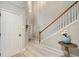Inviting foyer with a staircase, light wood floors, and a decorative table with a blue vase and white flowers at 690 Cobblestone Creek Ln, Mableton, GA 30126