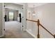 Bright hallway with carpet, white railing staircase, and a view into a spacious bedroom at 690 Cobblestone Creek Ln, Mableton, GA 30126