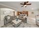 Spacious living room with open view to kitchen and dining room has a large sectional sofa, hardwood floors and modern ceiling fan at 690 Cobblestone Creek Ln, Mableton, GA 30126