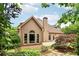 A backyard featuring mature landscaping, the rear of the house, and a stone patio at 1545 Center Cross Pass, Marietta, GA 30062
