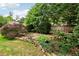 Secluded backyard with stone patio, pond, lush greenery, and rock wall with mature trees around the perimeter at 1545 Center Cross Pass, Marietta, GA 30062