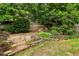 Expansive backyard featuring a stone patio, rock wall, lush greenery, and tranquil pond with waterfall at 1545 Center Cross Pass, Marietta, GA 30062