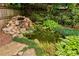 Beautiful backyard pond with stone waterfall feature surrounded by lush landscaping and natural privacy fence at 1545 Center Cross Pass, Marietta, GA 30062