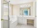 Bright bathroom features a vanity, a soaking tub with shower, and beige tile flooring at 1545 Center Cross Pass, Marietta, GA 30062